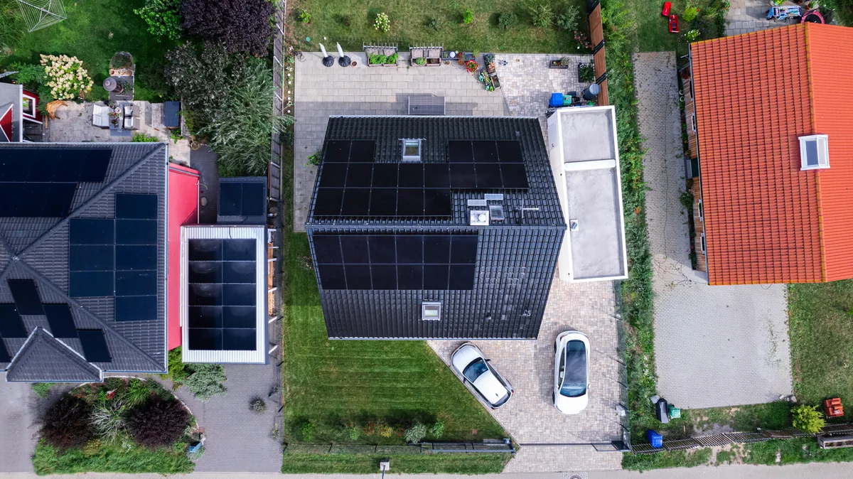 Drohnen-Luftaufnahme Einfamilienhaus mit Solaranlage, PV-Carport und Tesla in Berlin