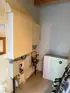 Wandschränke, Rohre und ein weißes "Solaredge Home Battery"-Gerät mit grüner Leuchtanzeige in einem Raum.