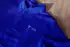 Blaues Poloshirt mit drei Knöpfen und weißem „TICON“-Logo auf der linken Brust.